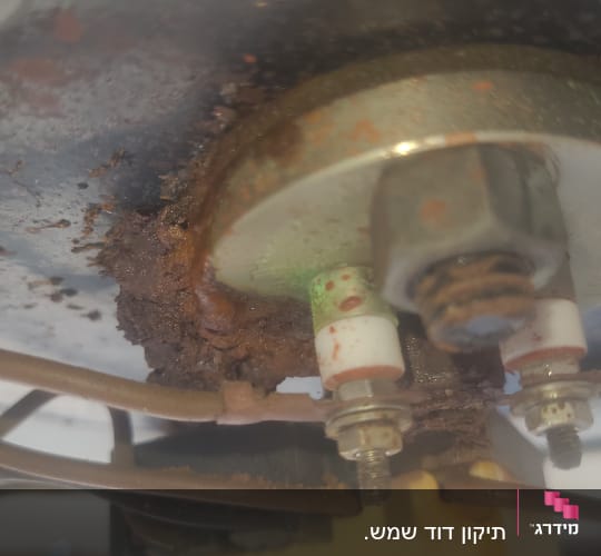 חלק תחתון של דוד שמש עם חלודה וחיבורים חשמליים